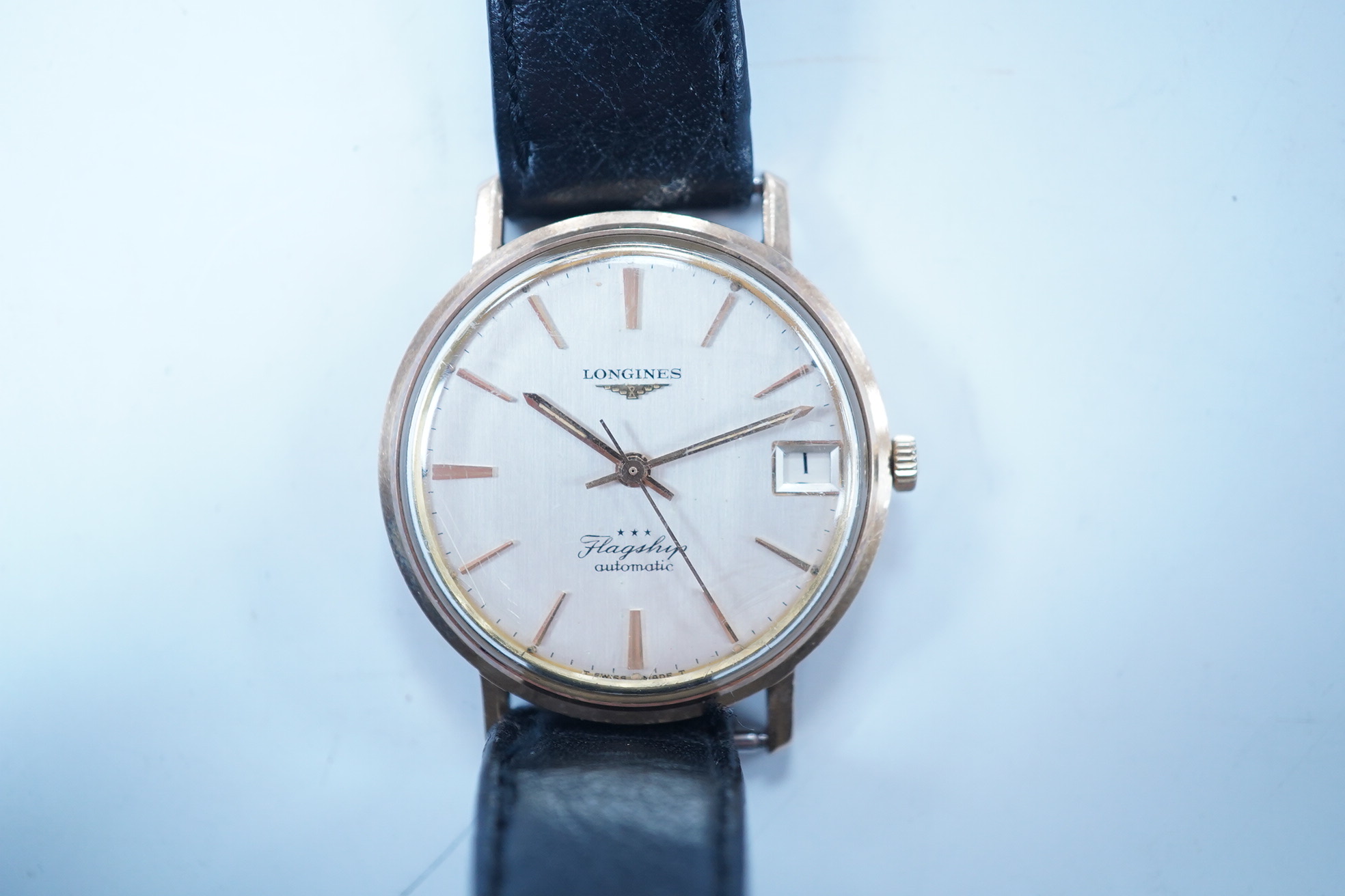 A gentleman's 9ct gold Longines Flagship automatic wrist watch, with baton numerals and date aperture, case diameter 35mm, on an associated leather strap. Condition - poor to fair